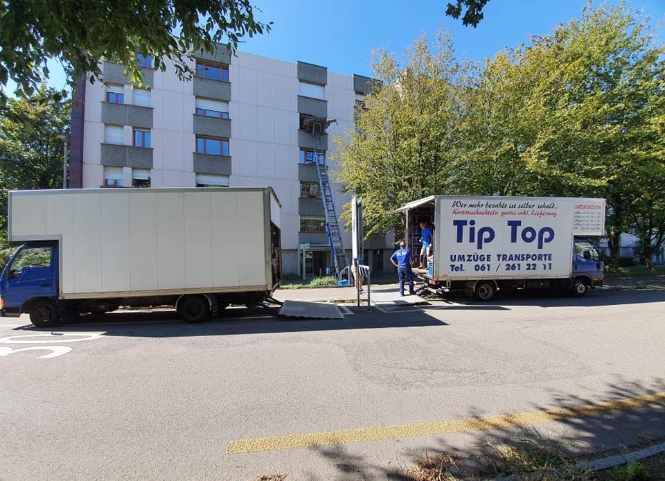 Mehrere Mitarbeiter und Umzugsfahrzeuge bei organisiertem Umzug in Basel